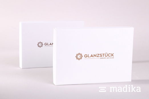 Weiß heißt nicht langweilig: Die Veredelung auf dem Deckel wertet die Stülpschachtel enorm auf. Weiße Stülpschachtel gekrempelt mit Veredelungs-Detail auf der Front.