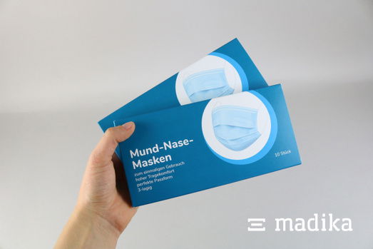 Faltschachteln nach Maß sind perfekt für OP-Masken geeignet, wie hier zu sehen ist. Zwei Faltschachteln nach Maß für OP-Masken