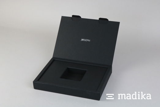 Die schlichte schwarze Klappschachtel setzt dank Veredelung ein i-Tüpfelchen Schwarze Klappdeckelschachtel mit Hohlwand und Veredelung