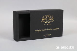 Schiebeschachteln mit Hohlwand und geschlossener Rückwand ermöglichen ein einfaches Öffnen. Schiebeschachtel mit Hohlwand und geschlossener Rückwand aus schwarzem Naturkarton