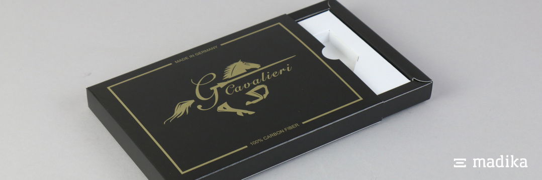 Schiebeschachteln können ganz einfach mit einem Inlay ausgestattet werden, um Ihre Produkte in Szene zu setzen. Schiebeschachtel mit schwarzer Bedruckung und weißem individuellem Inlay