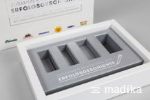 Geschenkverpackung mit Inlay, welches Platz für vier Produkte hat Bedrucktes Inlay einer Geschenkverpackung