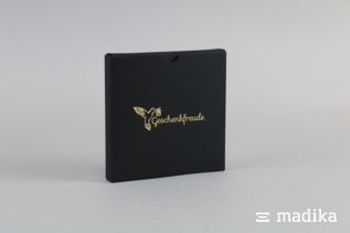 Heißfolienprägung auf einer schwarzen Schiebeschachtel. Heißfolienprägung schwarze Verpackung zum Schieben