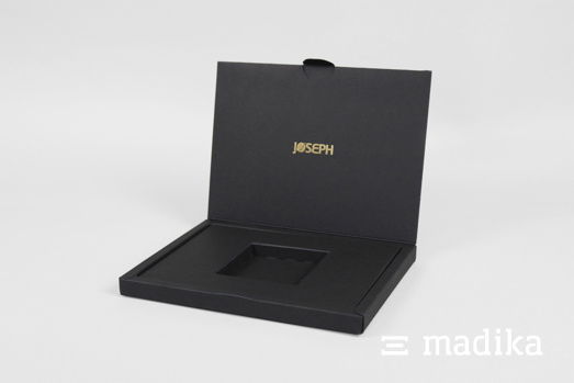 Klappschachtel mit Inlay aus schwarzem Karton und edler Heißfolienprägung. Schwarze Verpackung zum Aufklappen mit edler Heißfolienprägung