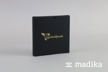 Die schwarze Schiebeschachtel ziert eine goldene Heißfolienprägung auf dem Deckel. Schiebeschachtel aus Karton schwarz mit Heißfolienprägung