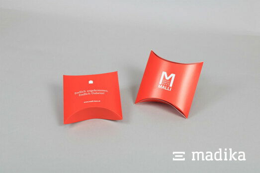 Zwei rote Kissenschachteln mit weißem Aufdruck Zwei Kissenschachteln in rot mit weißem Aufdruck