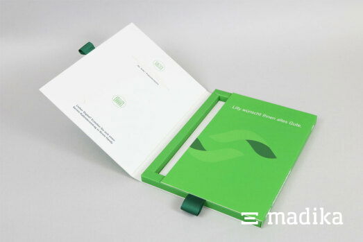 Eine grüne Klappschachtel mit Inlay und Ziehbändchen, welches wir auf individuelle Anfrage anpassen können. Eine grüne Klappschachtel mit Inlay