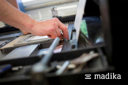 Hier werden die Stanzformen von Hand eingepasst. Der 3. Schritt im Herstellungsprozess. Stanzform einklemmen an der OHZ Stanzmaschine