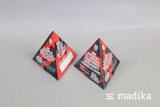 Auffällig, aufmerksamkeitsstark - direkte Kundenansprache für Tische und Tresen dank des pyramidenförmigen Werbeaufstellers. Pyramiden Aufsteller mit schwarz rotem Aufdruck