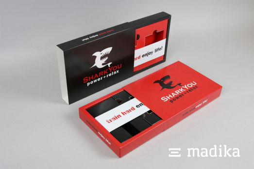 Das Corporate Design zieht sich hier von außen nach innen durch. Eine schwarze Schiebeschachtel mit Inlay