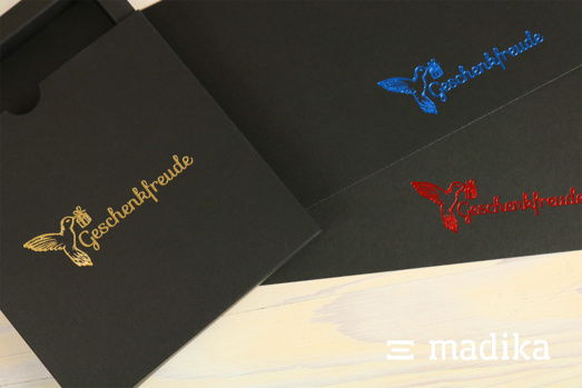 Heißfolienprägung auf schwarzen Geschenkschachteln. Heißfolienprägung auf einem Schwarzkarton