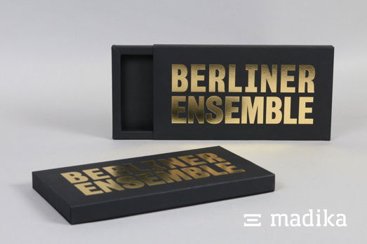 Ein schwarzer Schuber mit einer goldenen Heißfolienprägung Ein schwarzer Schuber mit einer goldenen Heißfolienprägung