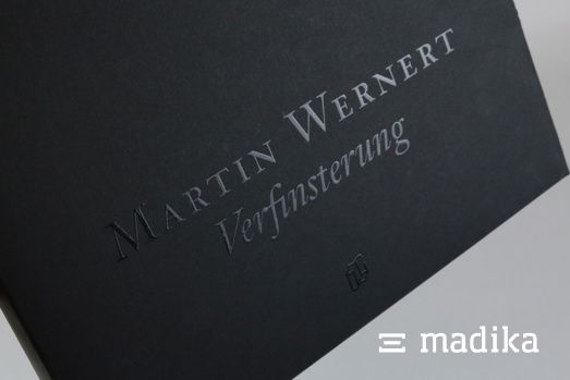 Partieller UV-Lack auf einer schwarzen unbedruckten Schachtel. Partieller UV-Lack auf einer schwarzen unbedruckten Schachtel