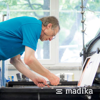 Mit Konzentration wird die Stanze eingestellt, damit die Form genau passt. Stanzen bei der Verpackungsdruckerei madika